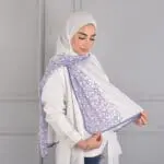 Hijab imprimé en crêpe Belle et Voilée by Nisreen, orné de motifs de lettres arabes, alliant élégance, finesse et qualité exceptionnelle. Fabrication syrienne. Dimensions : 65 x 180 cm