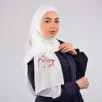 Hijab brodé en crêpe avec des fleurs rouges, signée Belle et Voilée by Nisreen, alliant élégance, finesse et qualité exceptionnelle. Fabrication syrienne. Dimensions : 65 x 180 cm
