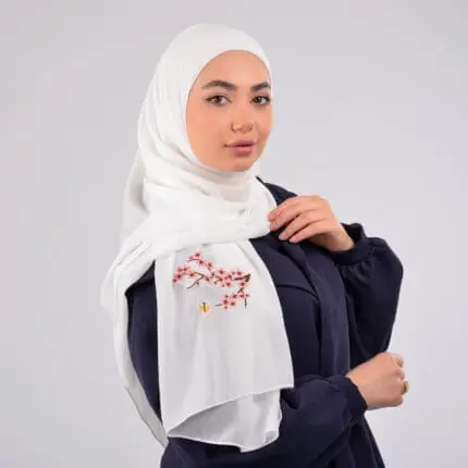 Hijab brodé en crêpe avec des fleurs rouges, signée Belle et Voilée by Nisreen, alliant élégance, finesse et qualité exceptionnelle. Fabrication syrienne. Dimensions : 65 x 180 cm