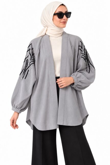 Femme voilée portant un cardigan gris brodé ouvert, vue de face