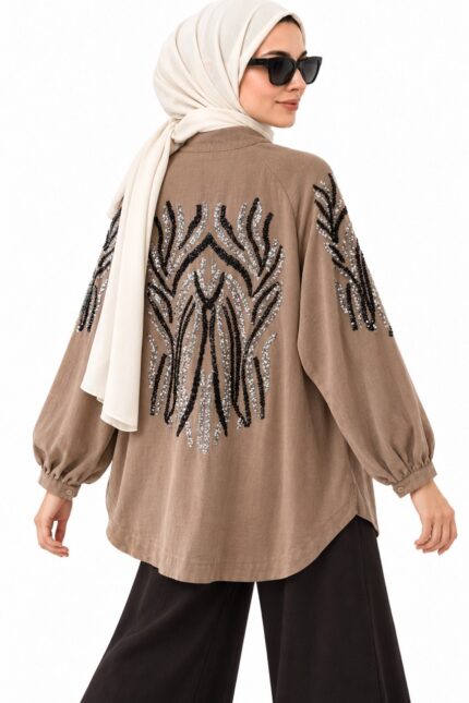Femme voilée portant un cardigan long brun-beige brodé à sequins noirs et argentés, vue trois-quarts