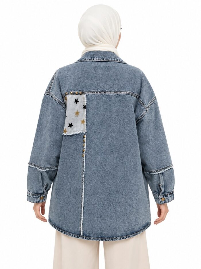 Veste en jean bleu délavé vue de dos sur une femme voilée, avec un empiècement clair à étoiles et une couture verticale effilochée
