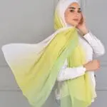 Hijab imprimé en crêpe Belle et Voilée by Nisreen, avec un dégradé jaune inspiré des aurores boréales, léger, fluide et élégant, parfait pour un style raffiné. Fabrication syrienne. Dimensions : 65 x 180 cm