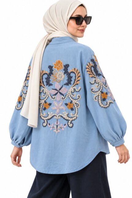 Cardigan long bleu clair, avec broderies florales colorées, porté par une femme voilée, vue trois-quarts dos