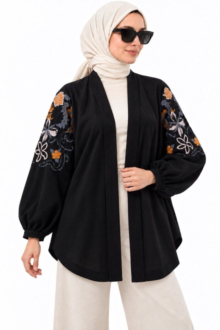 Vue de face du cardigan long noir à broderies florales sur les manches