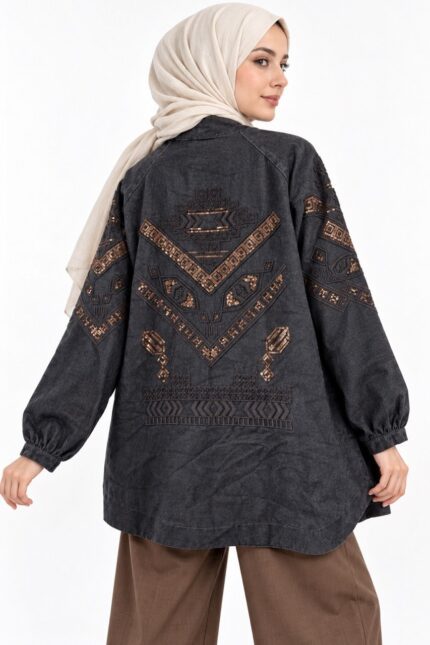 cardigan long en jean noir délavé brodé, avec broderies cuivrées géométriques, porté par une femme voilée, vue de dos.