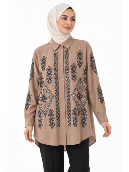 Tunique longue beige brodée vue de face sur une mannequin voilée, avec motifs géométriques et sequins sur le devant et les manches.