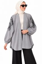 Femme voilée portant un cardigan gris brodé ouvert, vue de face