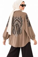 Hijabi woman wearing a long brown-beige cardigan embroidered with black and silver sequins, three-quarter view