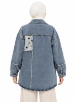Veste en jean bleu délavé vue de dos sur une femme voilée, avec un empiècement clair à étoiles et une couture verticale effilochée