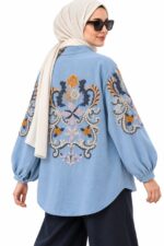 Long light blue cardigan with colourful floral embroidery worn by a hijabi woman – three-quarter back view