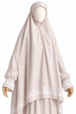 Détail du khimar rose poudré et de sa dentelle florale blanche